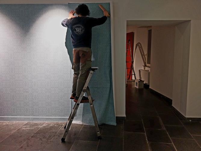 Allestimento delle sale con carte da parati colorate.